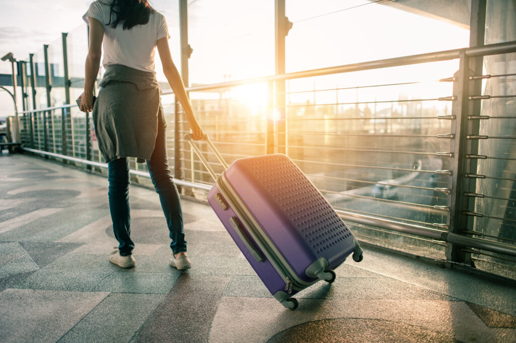 Traveller with suitcase at airport for Gatwick transfer service from Essex